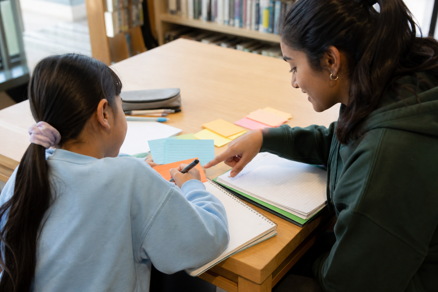 Student tutor using colourful study cards to explain a lesson in age-appropriate steps